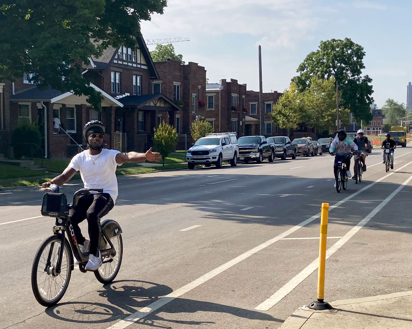 A Transportation Ambassador leads a group bike ride through a residential neighborhood.